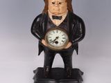 une statue représentant un homme tenant une horloge à la main