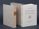 Deux livres sont ouverts sur une table, sur fond noir.