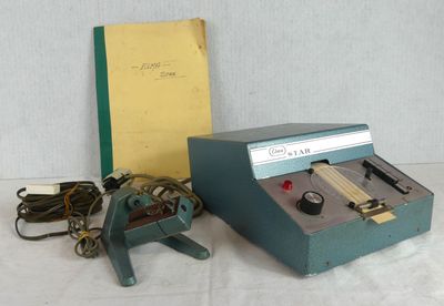 a small machine that is sitting next to a book