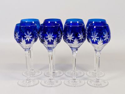 quatre verres à vin bleus sont alignés sur une surface blanche