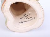 a small vase with writing on it sitting on a white surface