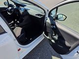 a white car with its door open in a parking lot