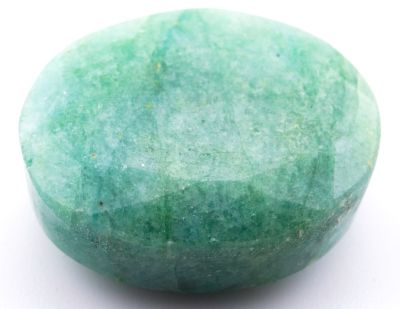 une photo d'une pierre verte posée sur une surface blanche