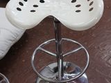 un tabouret blanc et une chaise blanche dans un salon