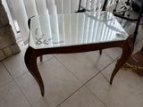 une table avec un plateau en verre placée devant une fenêtre