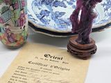 three vases and a plate on a table next to a piece of paper
