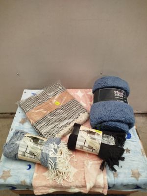 un tas d'objets posés sur un lit, avec un chapeau dessus