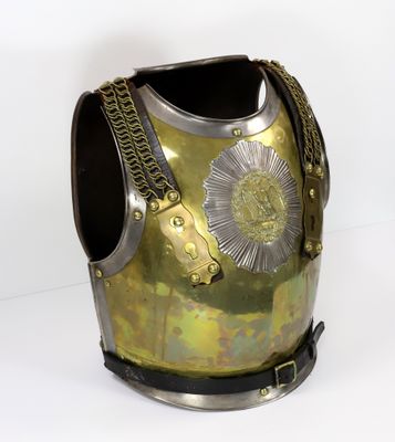 une armure dorée et argentée exposée sur fond blanc