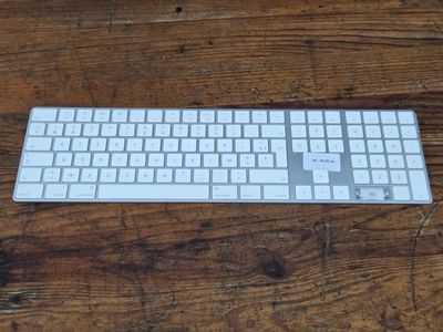 a white keyboard sitting on a wooden table