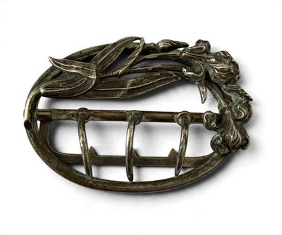 an image of a metal broochle with a bird on it