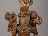 bronze statue of three children playing with a bucket of water