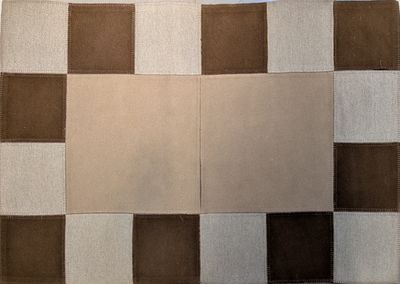 un tapis en patchwork marron et blanc posé sur une table blanche