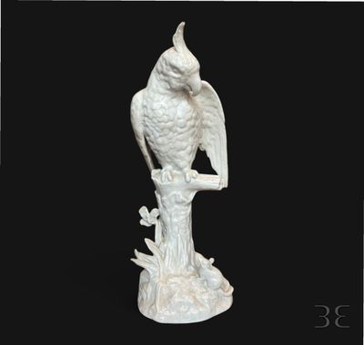 une statue blanche représentant un oiseau perché sur une souche d'arbre