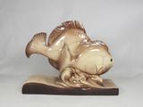 a statue of a fish that is sitting on a book
