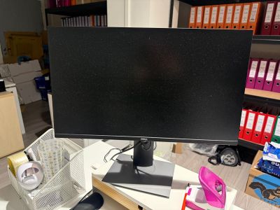 un écran d'ordinateur posé sur un bureau dans une pièce