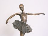 bronze statue of a young ballerina in a tutu on a marble base