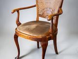 an image of a chair with a cane back and a seat made of wood
