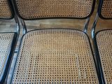 four chairs with black frames and wicker seats in a living room