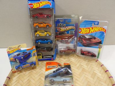 il y a plein de petites voitures Hot Wheels sur la table