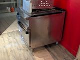 un micro-ondes posé sur une cuisinière dans une cuisine