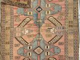 an old rug is laying on the floor next to a wall