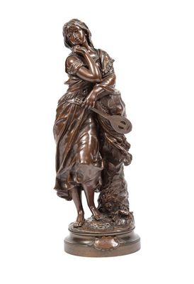 une statue en bronze représentant une femme tenant un enfant et un chien dans ses bras