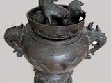a bronze vase with a horse and a dog in it