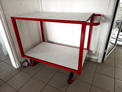 a red and white cart sitting on a tiled floor