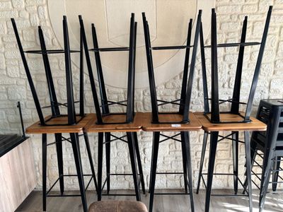 Dans une pièce, plusieurs chaises sont alignées contre un mur de briques.