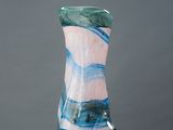 un vase en verre posé sur un socle blanc