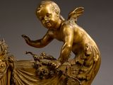 a gold statue of a baby sitting on a bed
