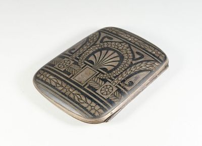 an antique silver cigarette case with a design on it