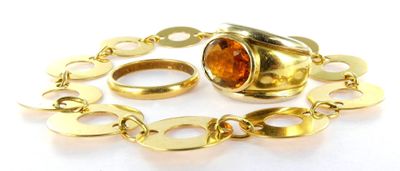 un gros plan d'un bracelet en or sur lequel est enfilée une bague