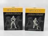 a pair of star wars action figures sit in front of a box