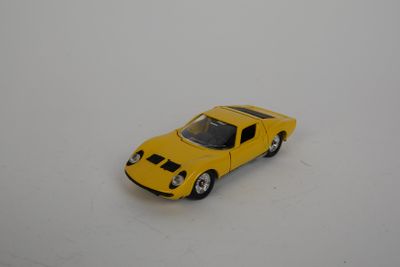 une petite voiture jaune posée sur une surface blanche