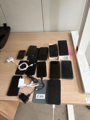 many cell phones on a table with a laptop on it