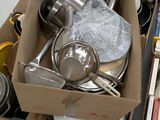 many boxes of cooking utensils and cookware on the floor