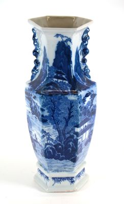 un vase bleu et blanc posé sur une surface blanche