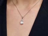 a close up of a woman wearing a necklace with a bird on it
