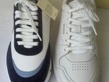 pair of white and blue sneakers sitting on top of a white counter
