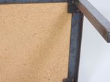 an old metal frame with a cork board attached to it