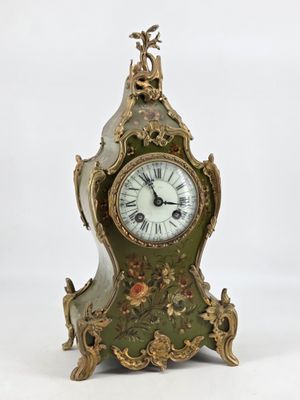 a green and gold clock sitting on a white surface