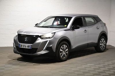 Le SUV argenté est garé dans le garage, sur un sol à damier.