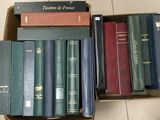beaucoup de livres dans une boîte posée sur le sol