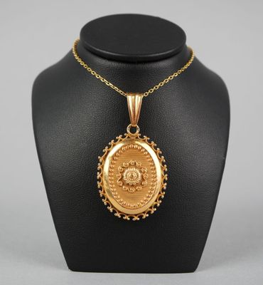 un collier en or avec un médaillon sur un mannequin noir