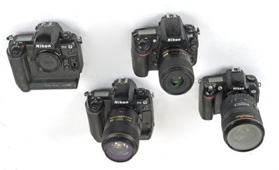 four cameras are lined up in a row on a white surface