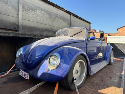 une Coccinelle VW bleue garée sur le bord de la route