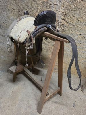 une selle de cheval posée sur un support en bois