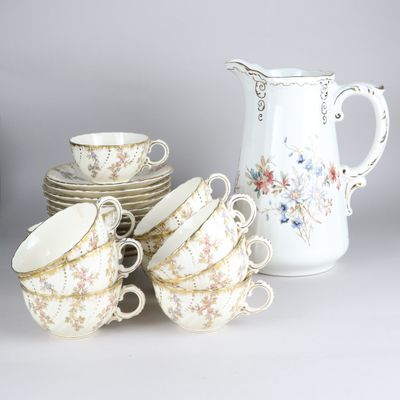 a lot of cups and saucers sitting on a table