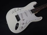 an image of a white electric guitar with a signed signature on it